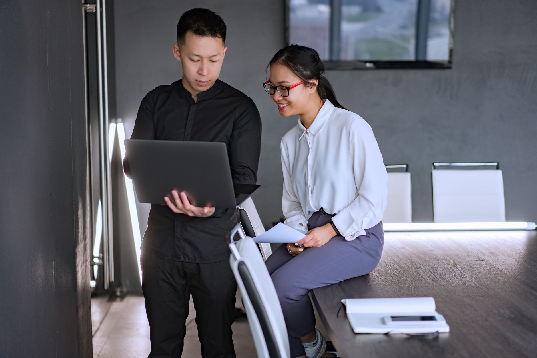 Two professionals collaborating in an office with a laptop, discussing documents and ideas — illustrating: Cloud Backup vs Traditional Backup: Which Strategy Protects Your Central Florida SMB Data Better?